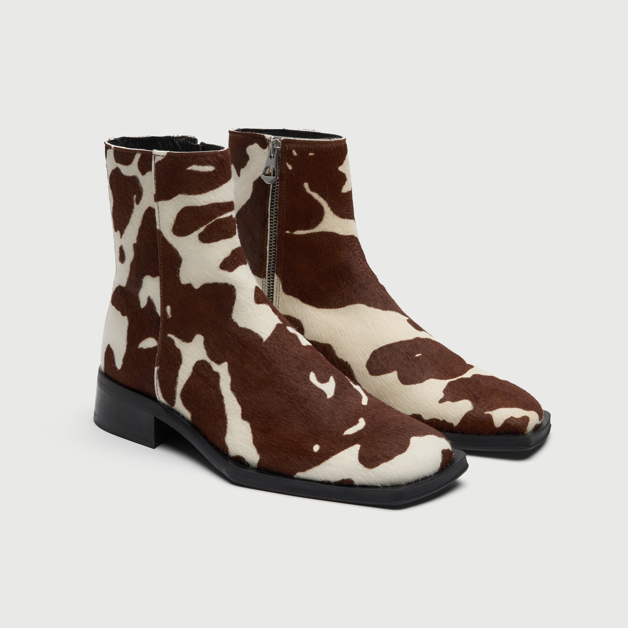 Walk London Abbey Zip Up Cuban Heel Ankle Boots in brown and white cow print hair on leather three quarter view