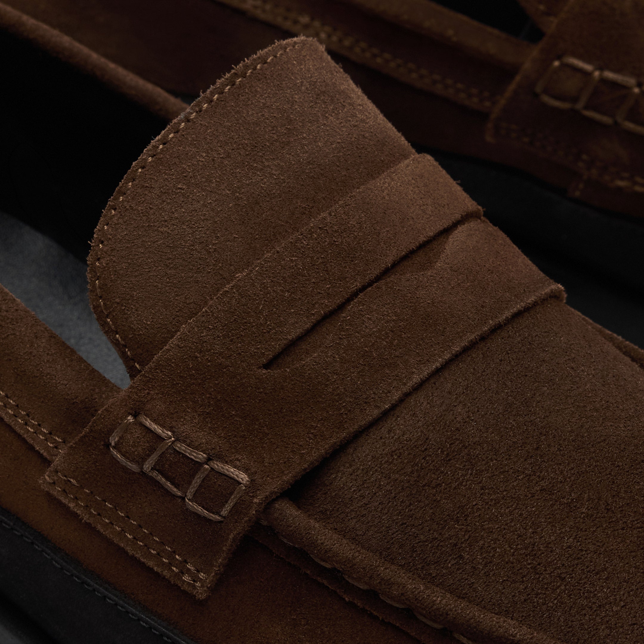 Walk London Battersea Saddle Hybrid Loafer in brown and black suede close up of saddle strap and beefroll stitching