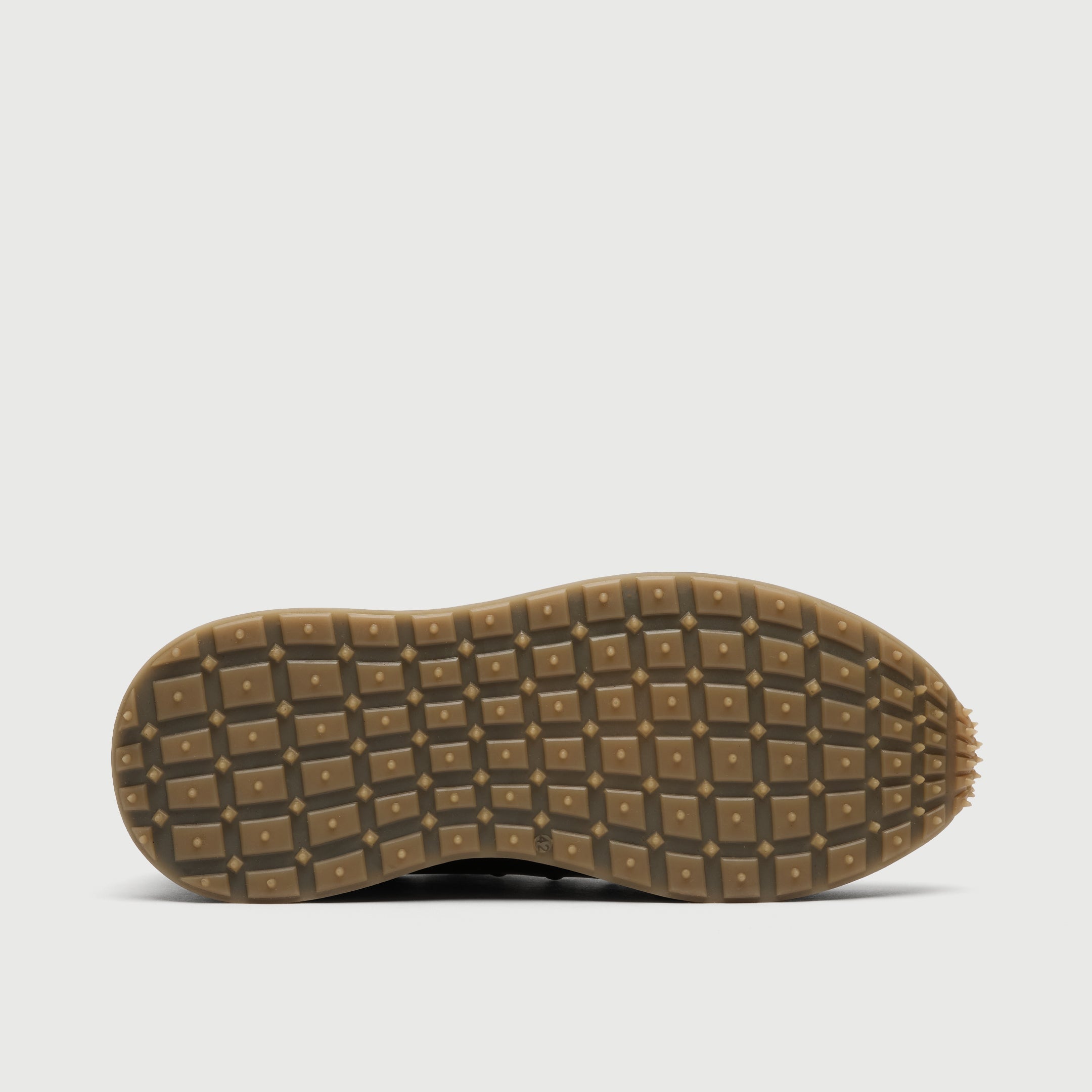 Close-up of a brown shoe sole with tread pattern on a light gray background Walk London