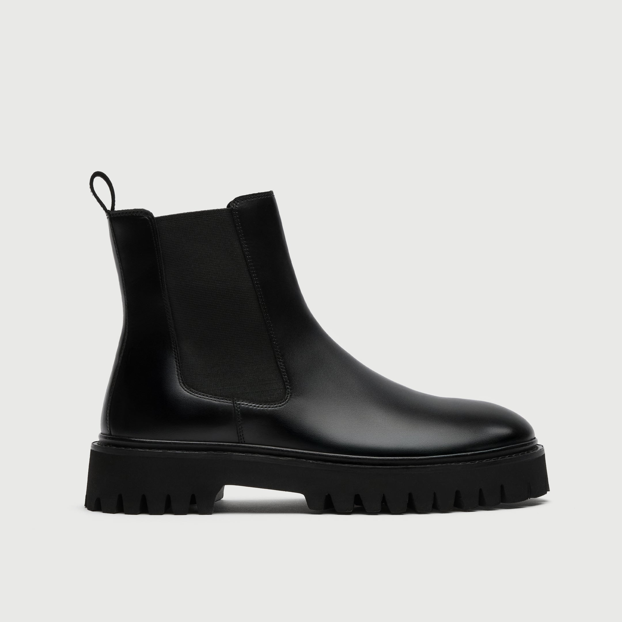 Black Chelsea boot on a light gray background
