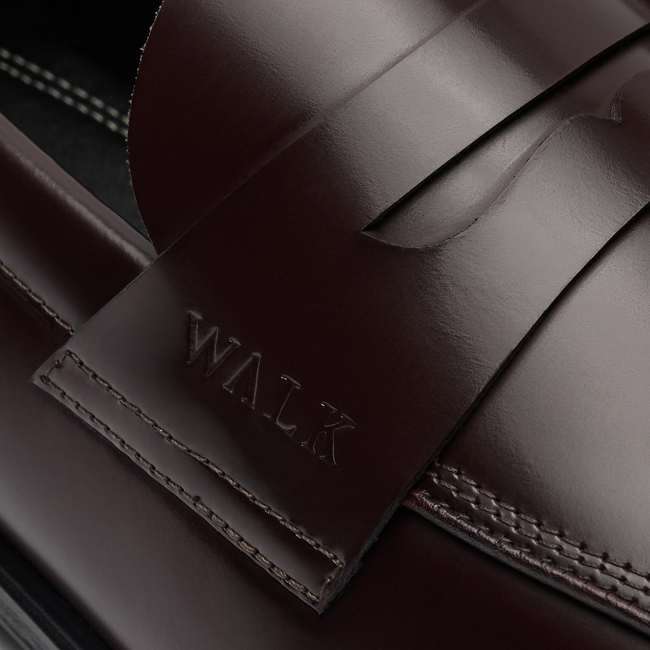 Walk London Marylebone Saddle Loafers in Dark Burgundy Leather close up of embossed branding on the side of the saddle strap and stitching detailing.