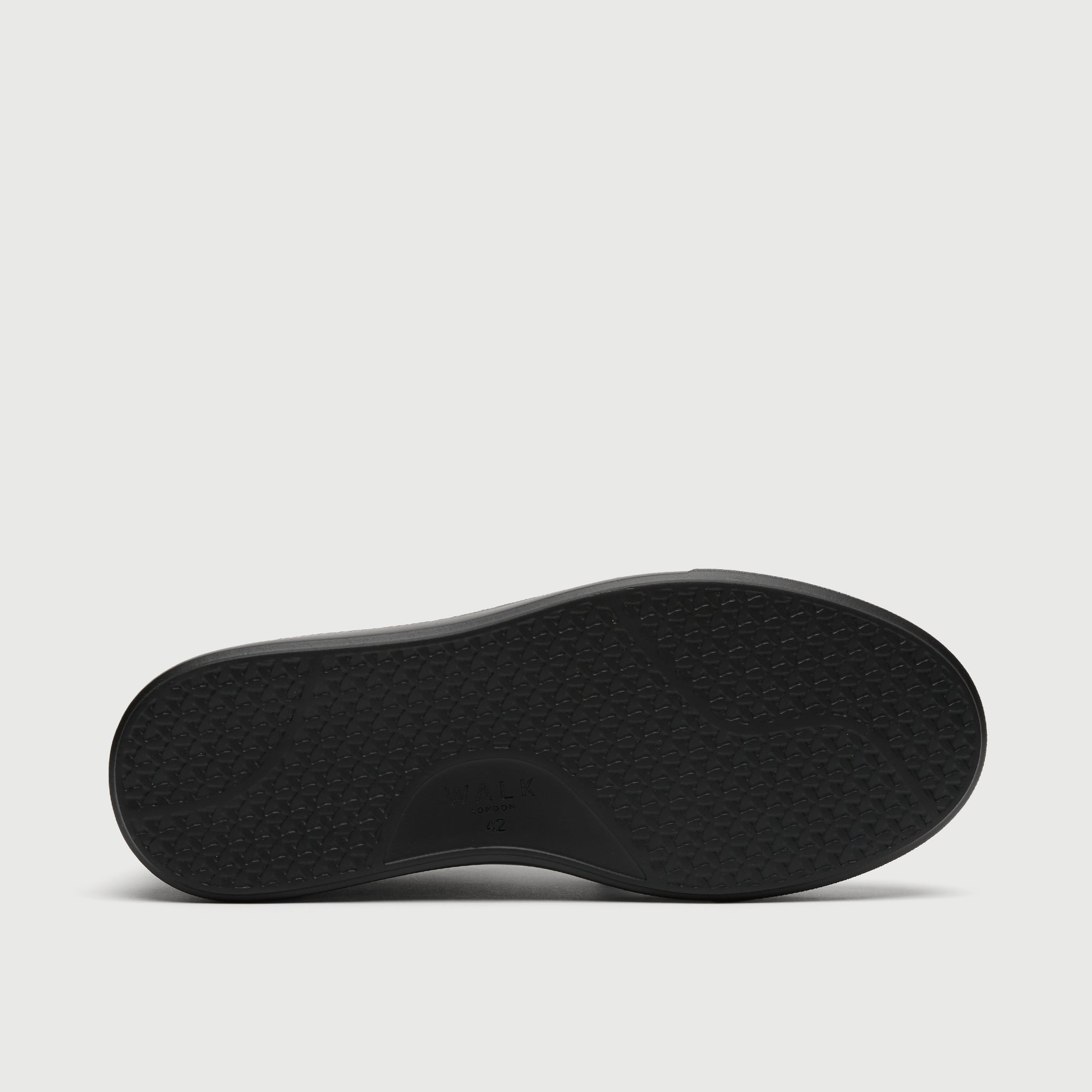 Black shoe sole on a light gray background - Walk London Pasadena Trainer in Black Leather
