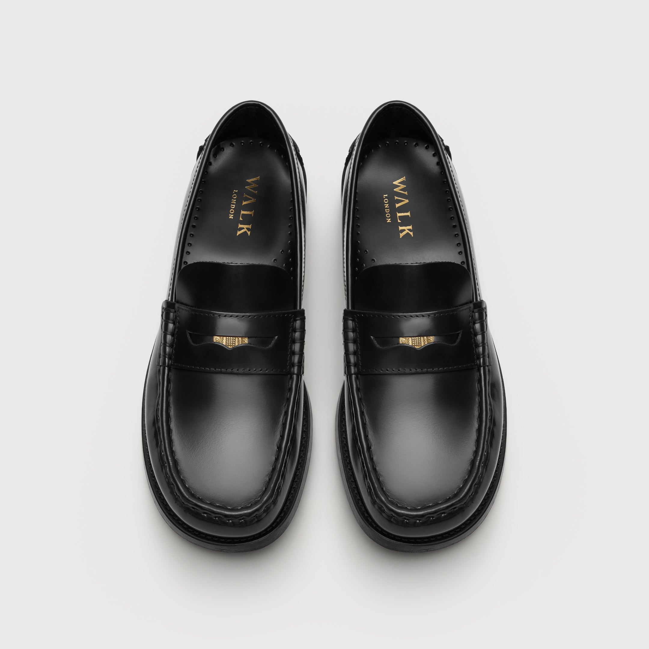 Walk London Shoreditch Penny Loafer in Black Leather top view showing squared toe shape, gold foil branding on insole, and gold penny stored in the saddle strap