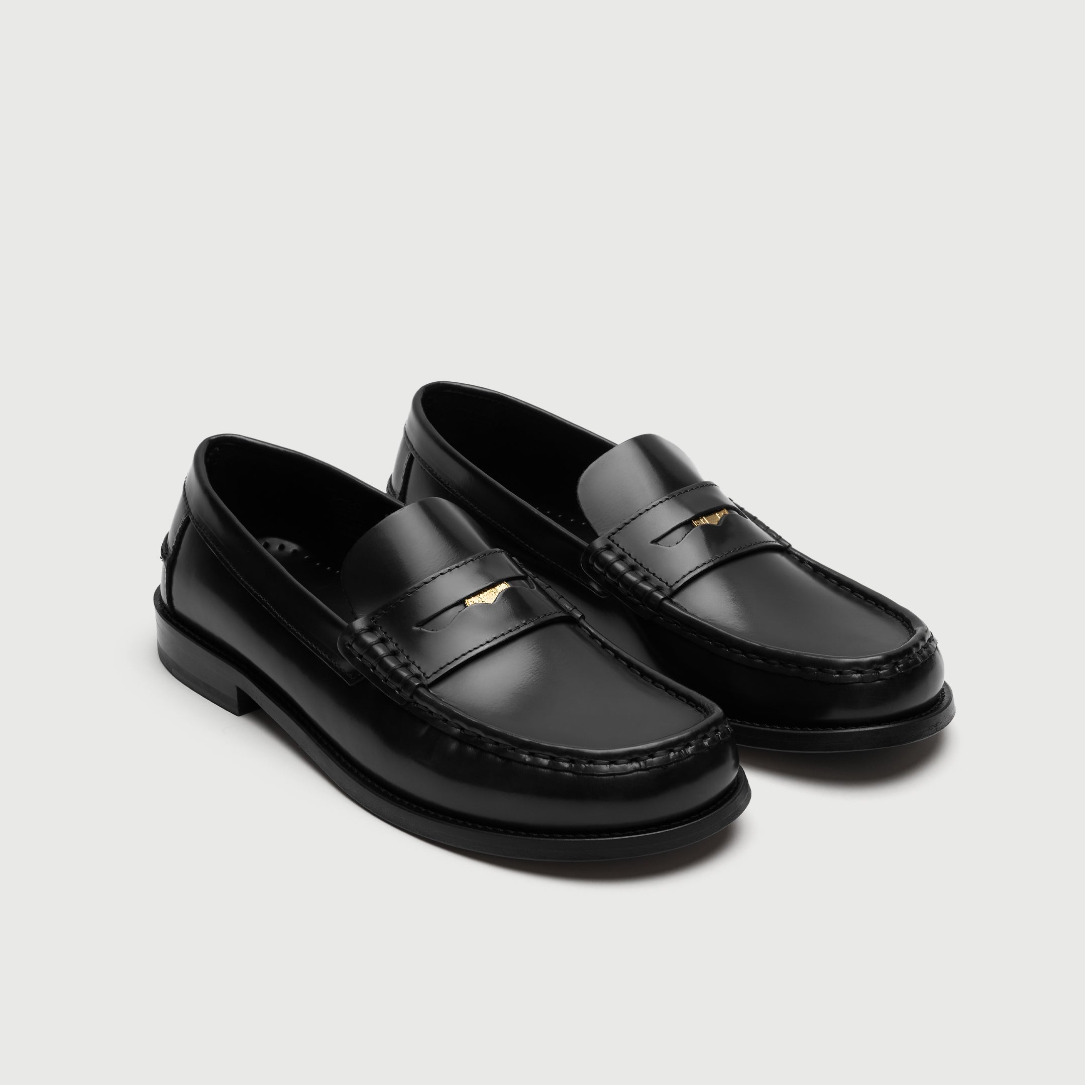 Walk London Shoreditch Penny Loafers in Black Leather showing gold penny stored in the saddle strap