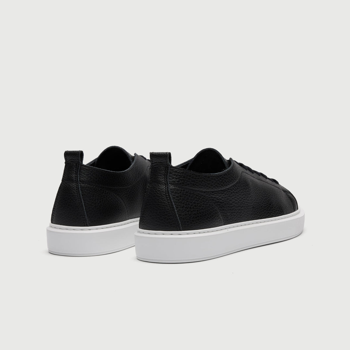Walk London Wimbledon Trainer in Black Grain Leather heel view showing pull tab and vent holes on the side
