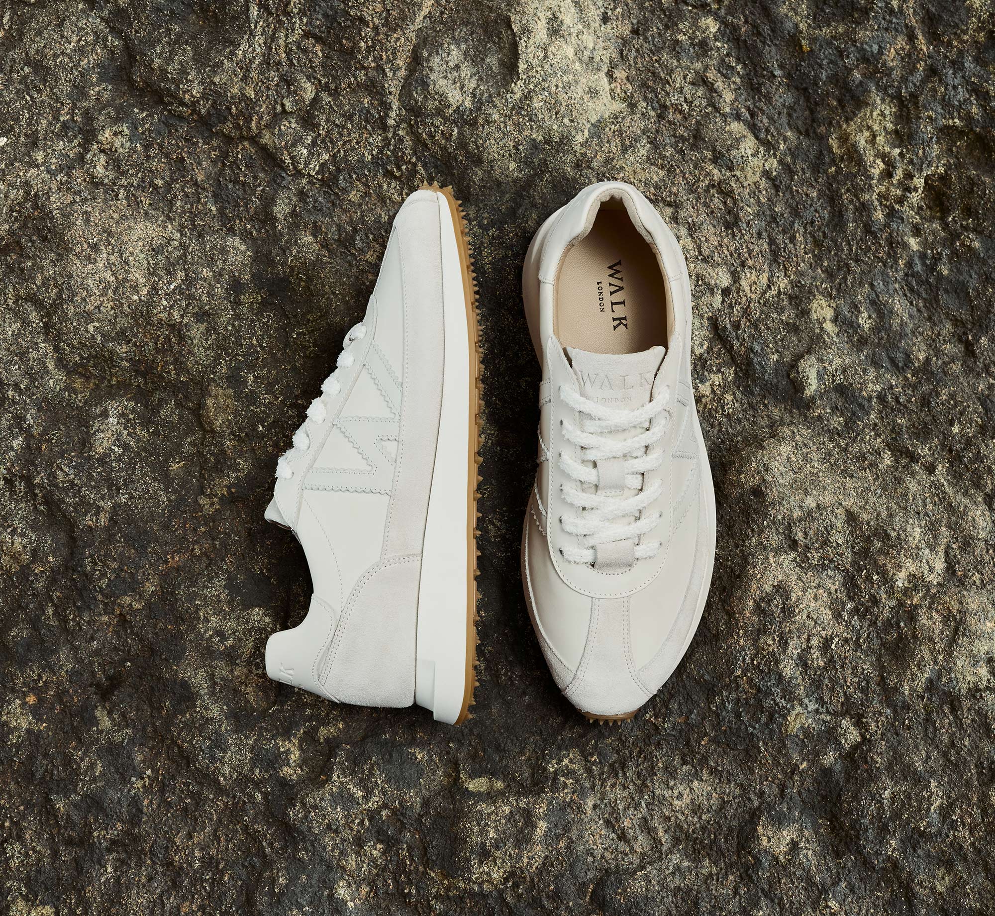 Chiswick mens white leather trainers on dark sandy rock