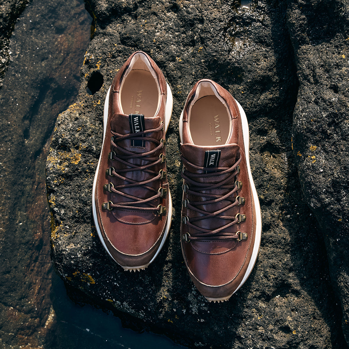 Hampstead mens brown leather hiking style trainers on black rocks 