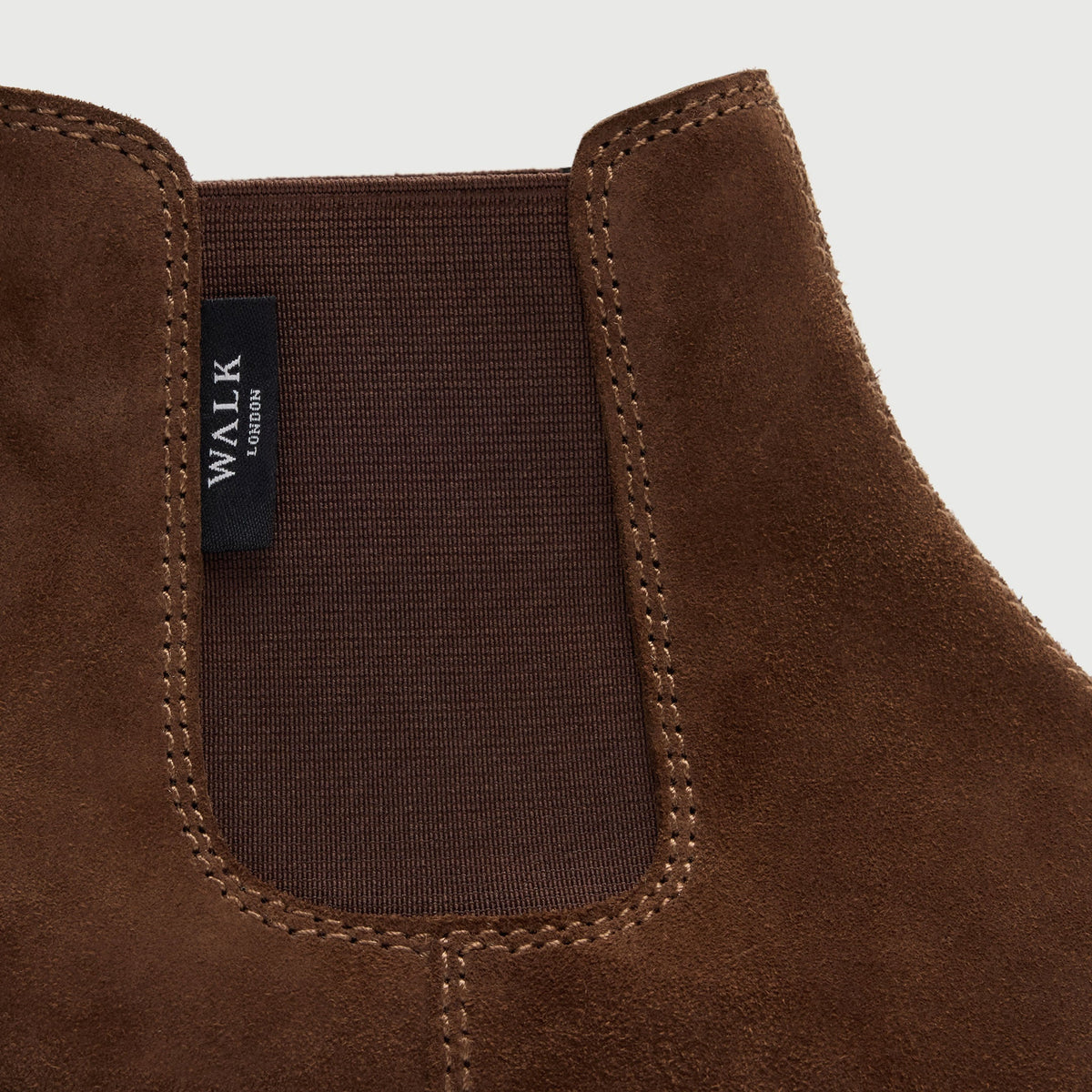 Walk London Clapham Chelsea Boot in tan suede close up of elastic side panel, stitching, and branded tab detail