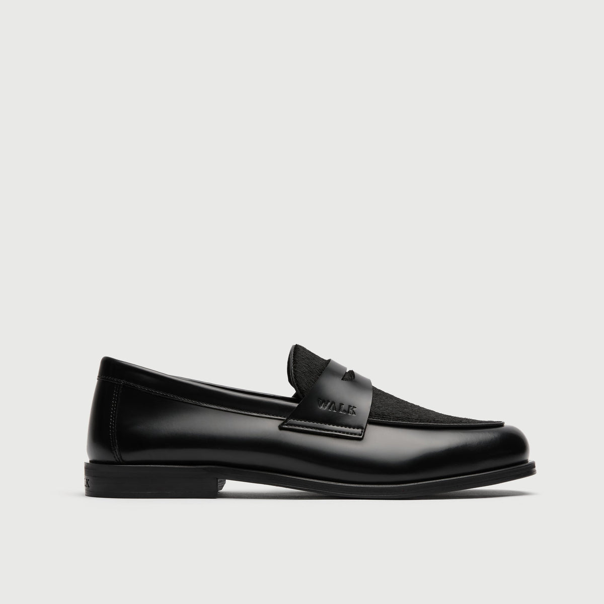 Walk London Grosvenor Saddle Loafer black smooth leather with black pony hair vamp side view showing debossed branding on side of saddle strap