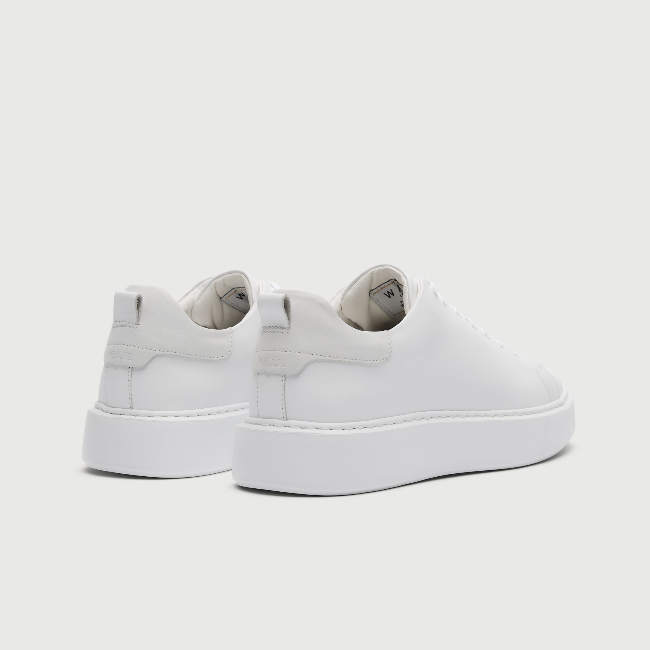 White slip-on sneakers on a light gray background - Walk London Pasadena Trainer in White Leather