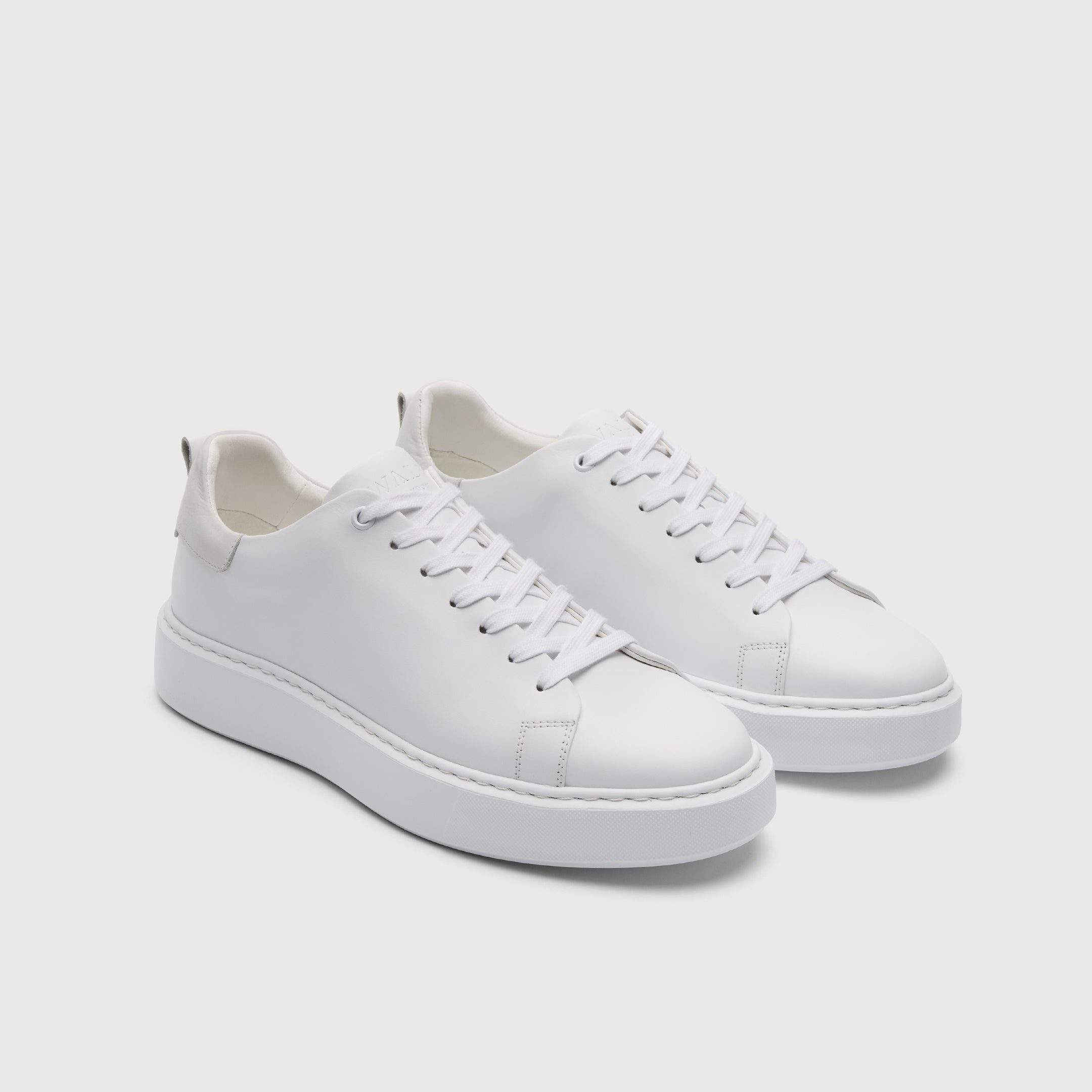 White sneakers on a light gray background - Walk London Pasadena Trainer in White Leather