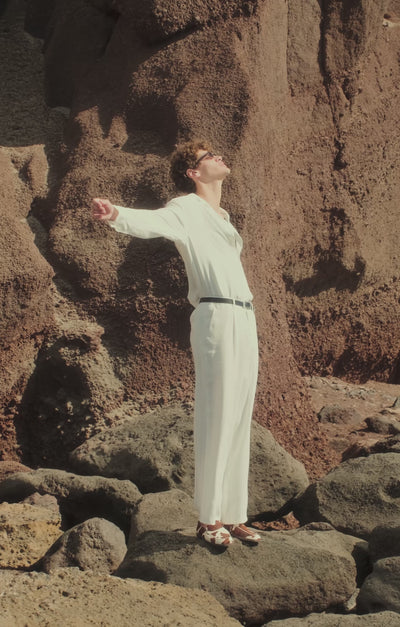 Video of man in summer outfits in a coastal landscape wearing loafers and sandals 