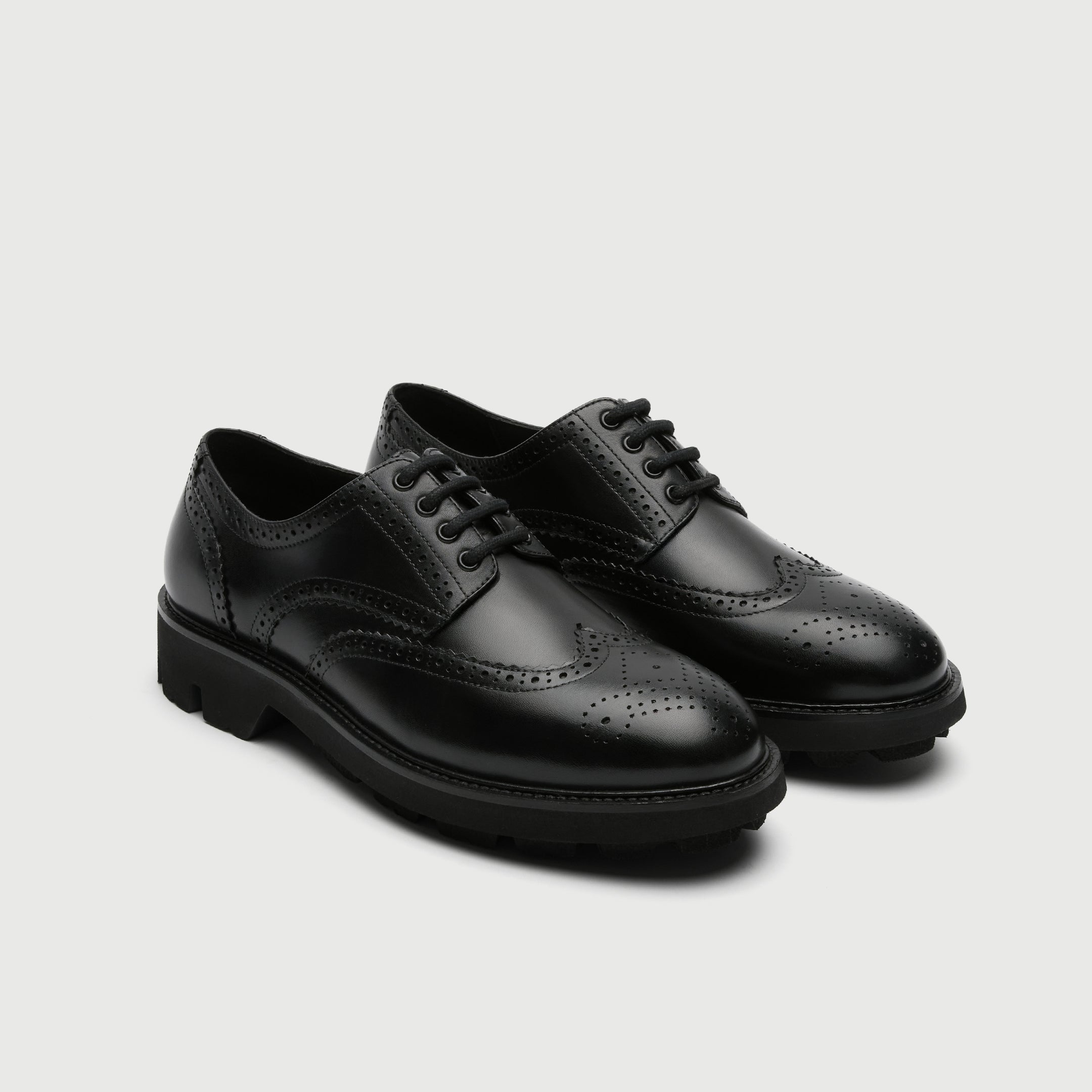 Pair of black leather Walk London Felix brogue shoes on a light grey background