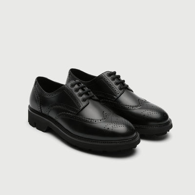 Pair of black leather Walk London Felix brogue shoes on a light grey background