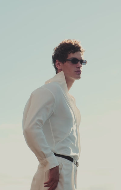Video of man in summer outfits walking along coastal landscape wearing loafers and sandals
