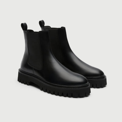 Pair of black rubber boots from Walk London Shoes on a light grey 