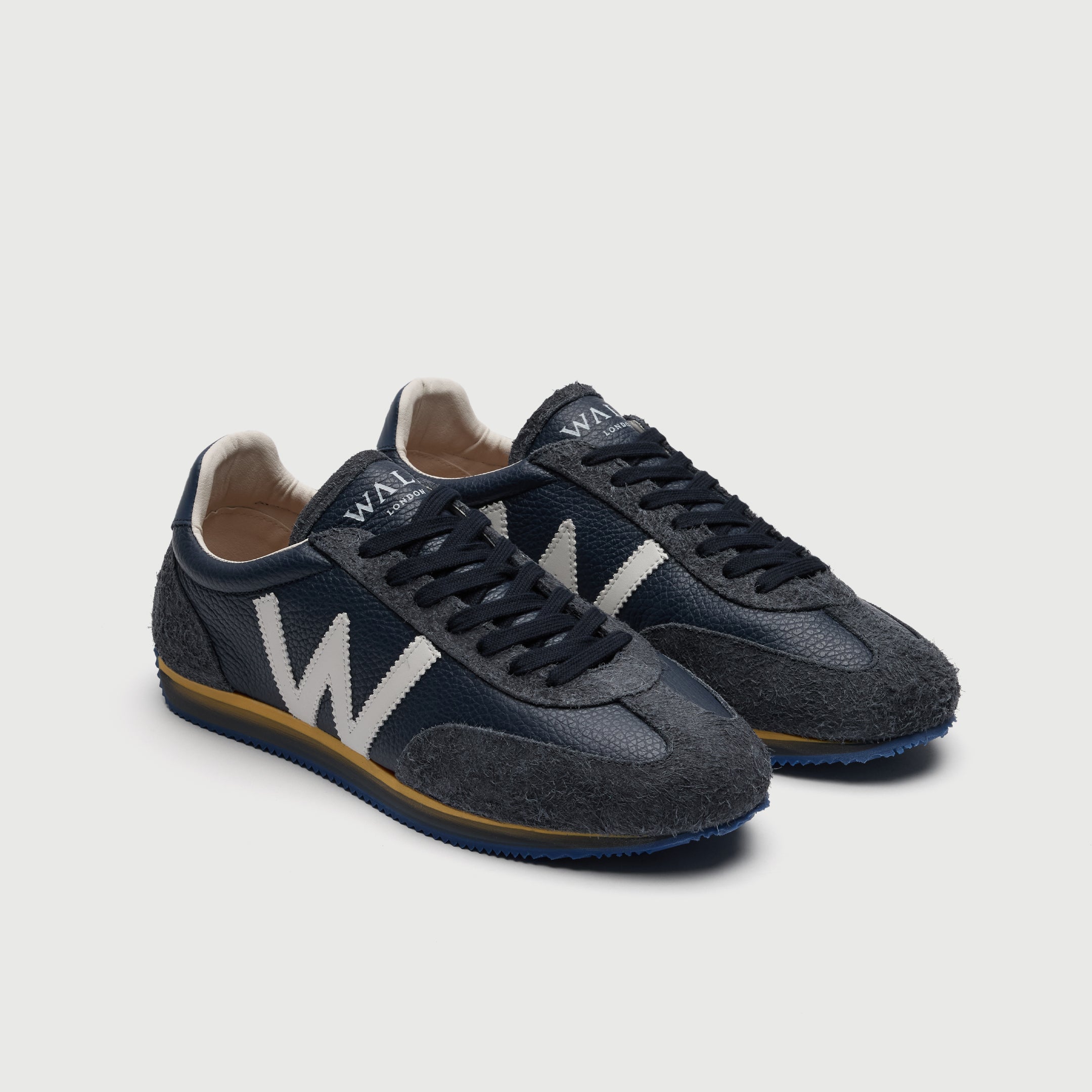 Walk London Retro Runner Trainers in Blue Brushed Suede and Grain Leather three quarter view showing seven eyelets with dark blue laces and white branding on tongue