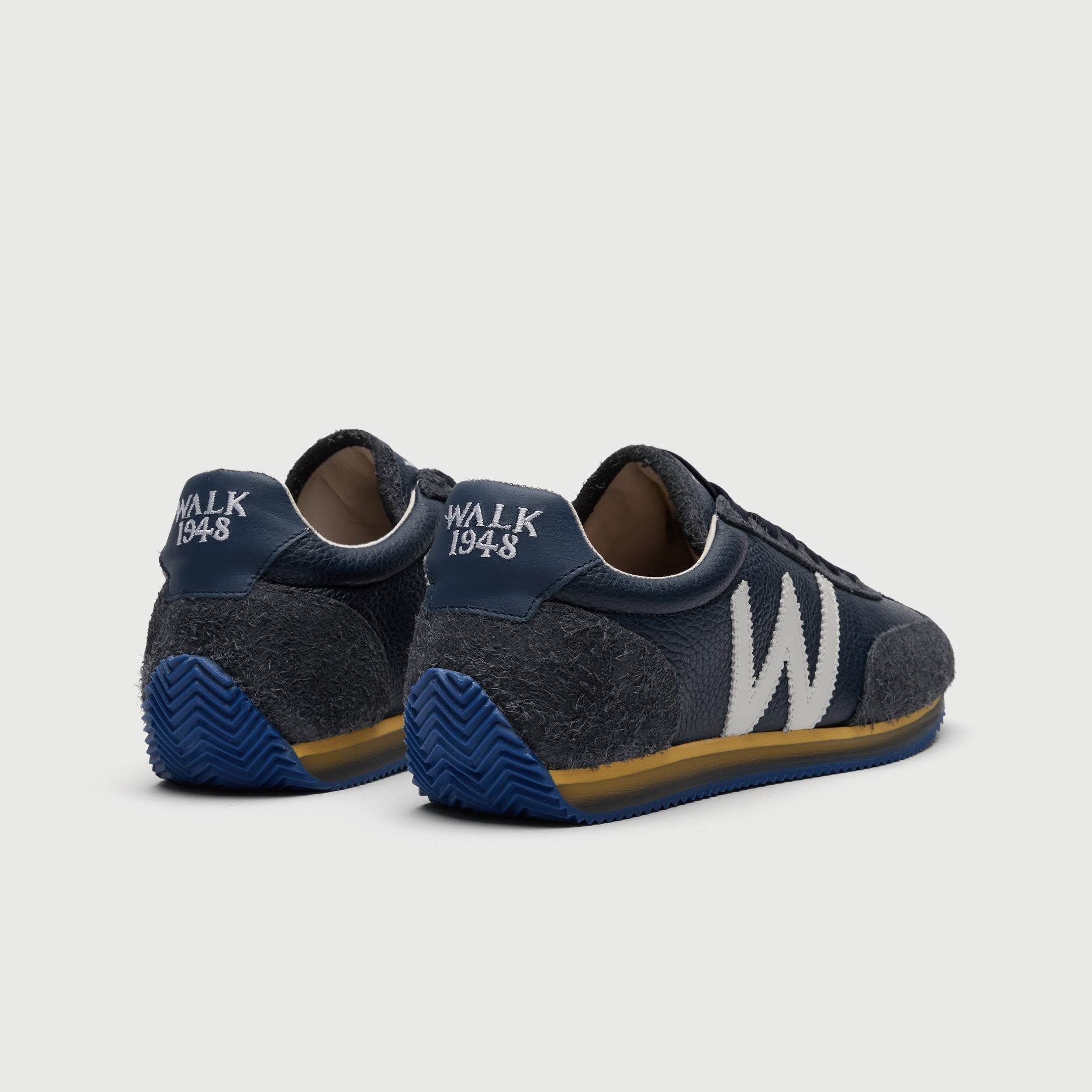 Walk London Retro Runner Trainers in Blue Brushed Suede and Grain Leather heel view showing blue ridged sole that extends into heel guard, yellow and translucent midsole, embroidered WALK 1948 heel counter
