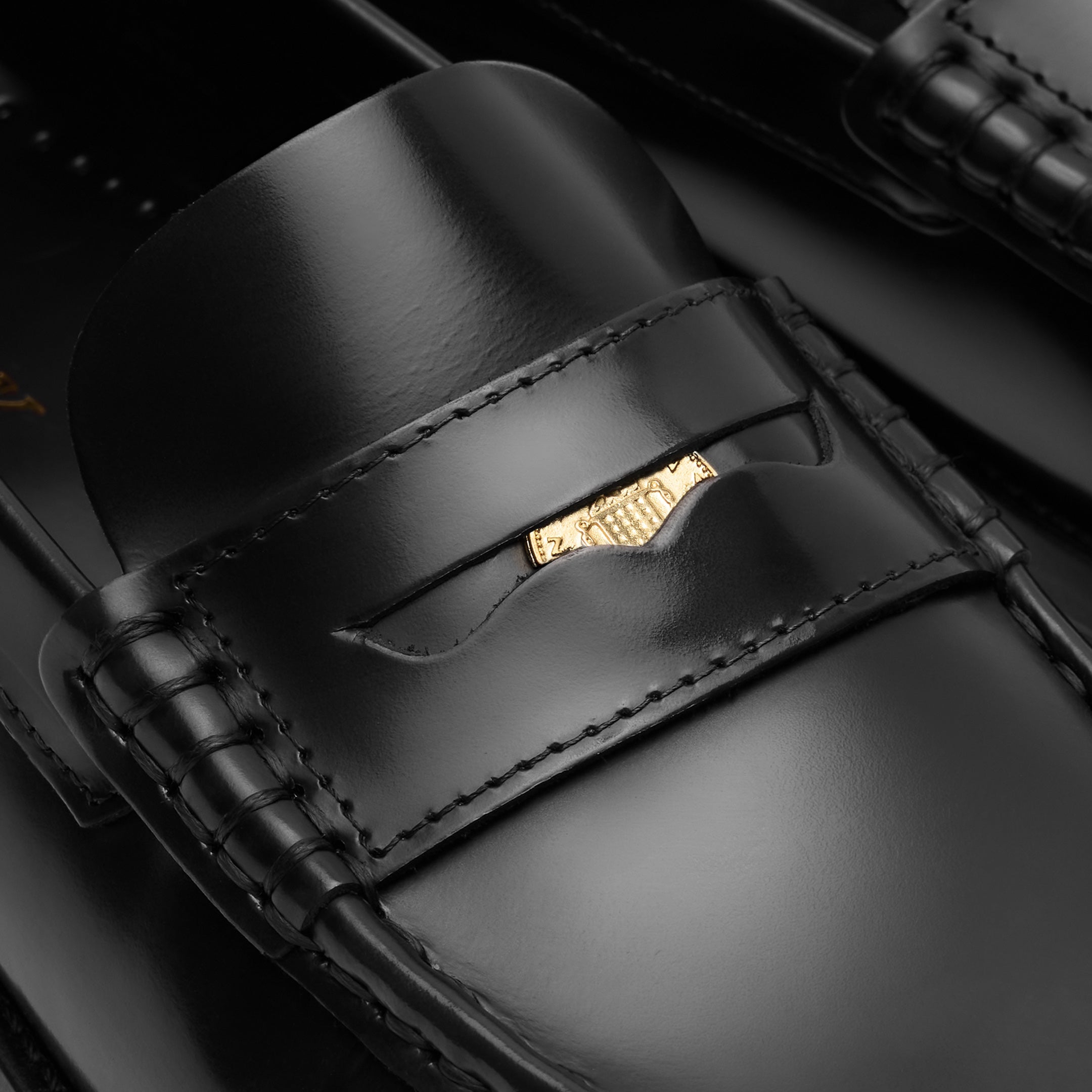Walk London Shoreditch Penny Loafer in Black Leather close up of gold penny tucked into the saddle strap and beefoll stitching