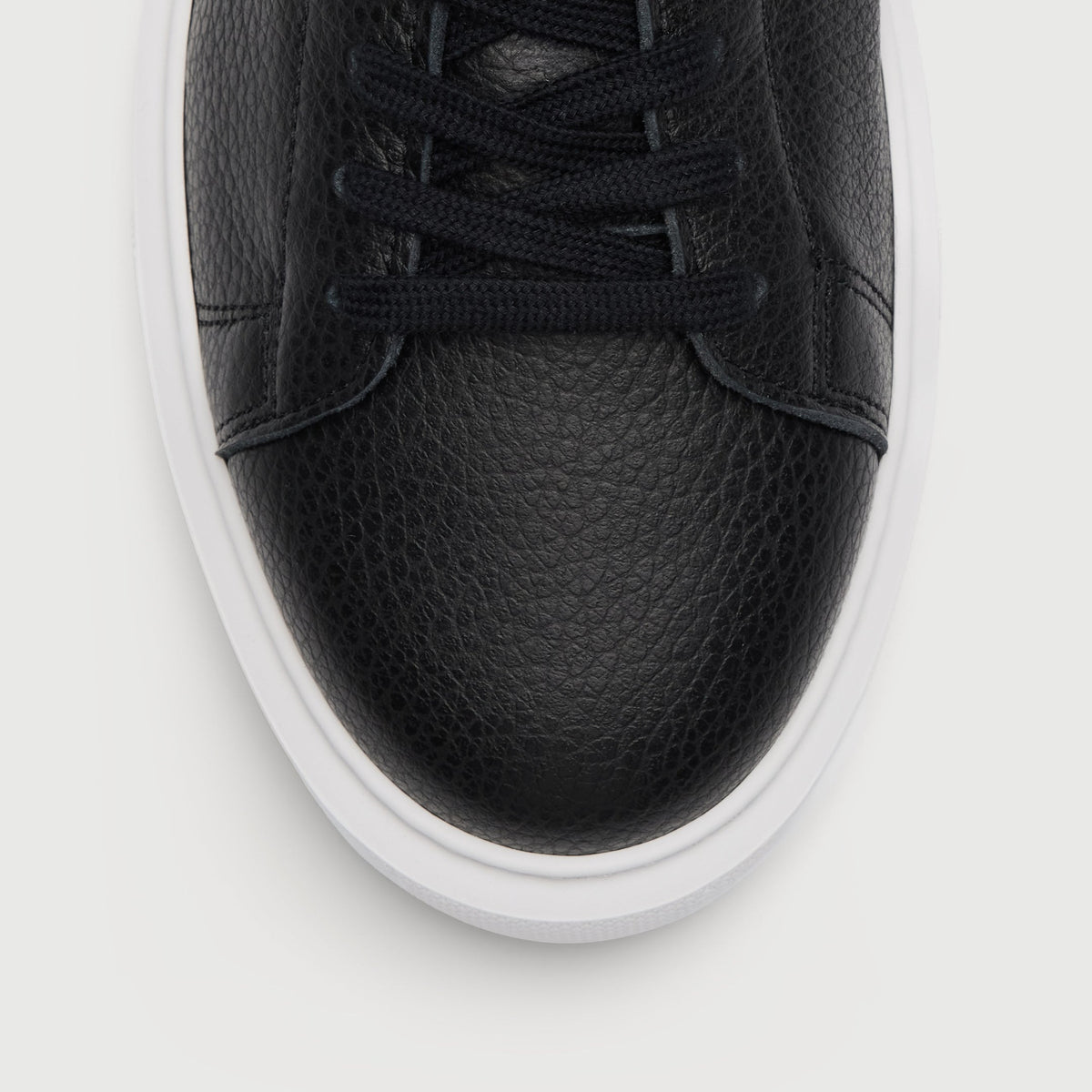 Walk London Wimbledon Trainer in Black Grain Leather close up of grain texture on toe and flat lack laces